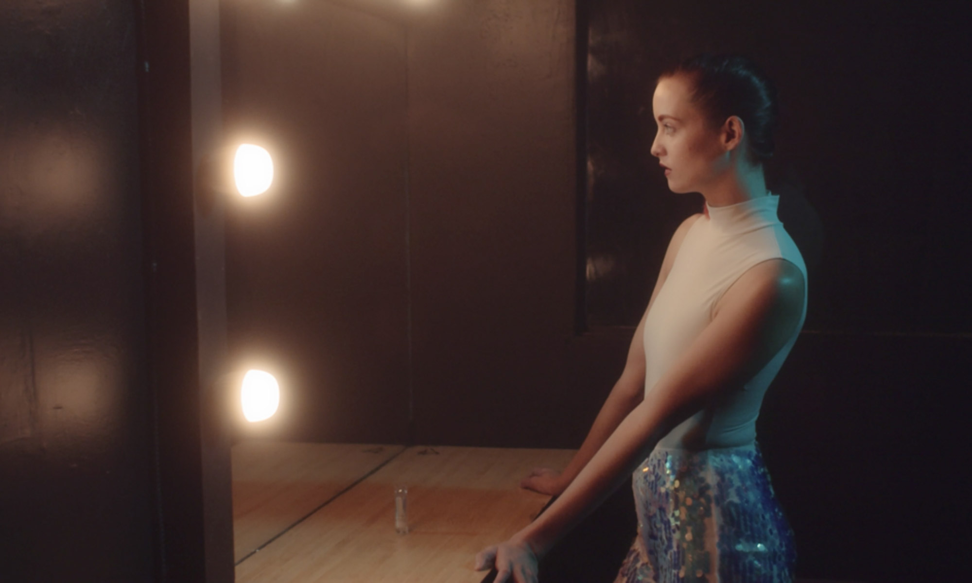 Piękna kobieta przeglądająca się w lustrze oświetlanym przez żarówki LED Aputure Accent B7c