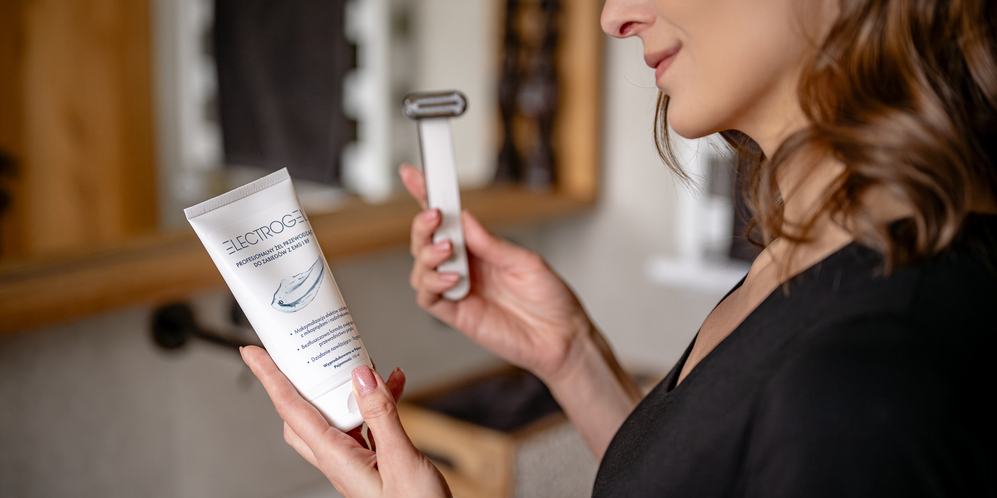 Żel przewodzący Humanas Electrogel trzymany w dłoni przez kobietę. W drugiej ręce trzyma urządzenie wykorzystujące technologie EMS i RF