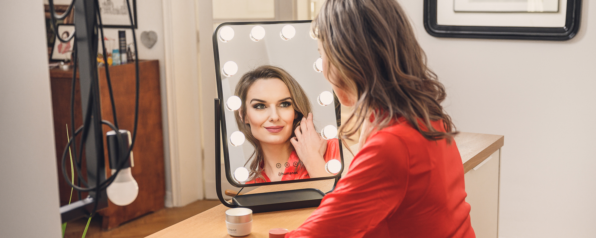 Young woman browses in mirror with LED lighting
