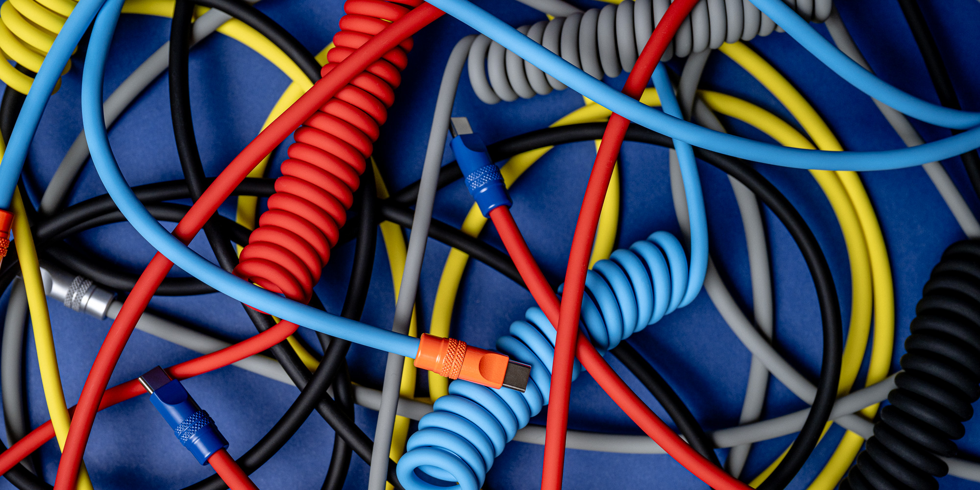 Kabel Newell USB-C - USB-C 100 W, 1,5 m, silikonowy, spiralny, pomarańczowo-żółty