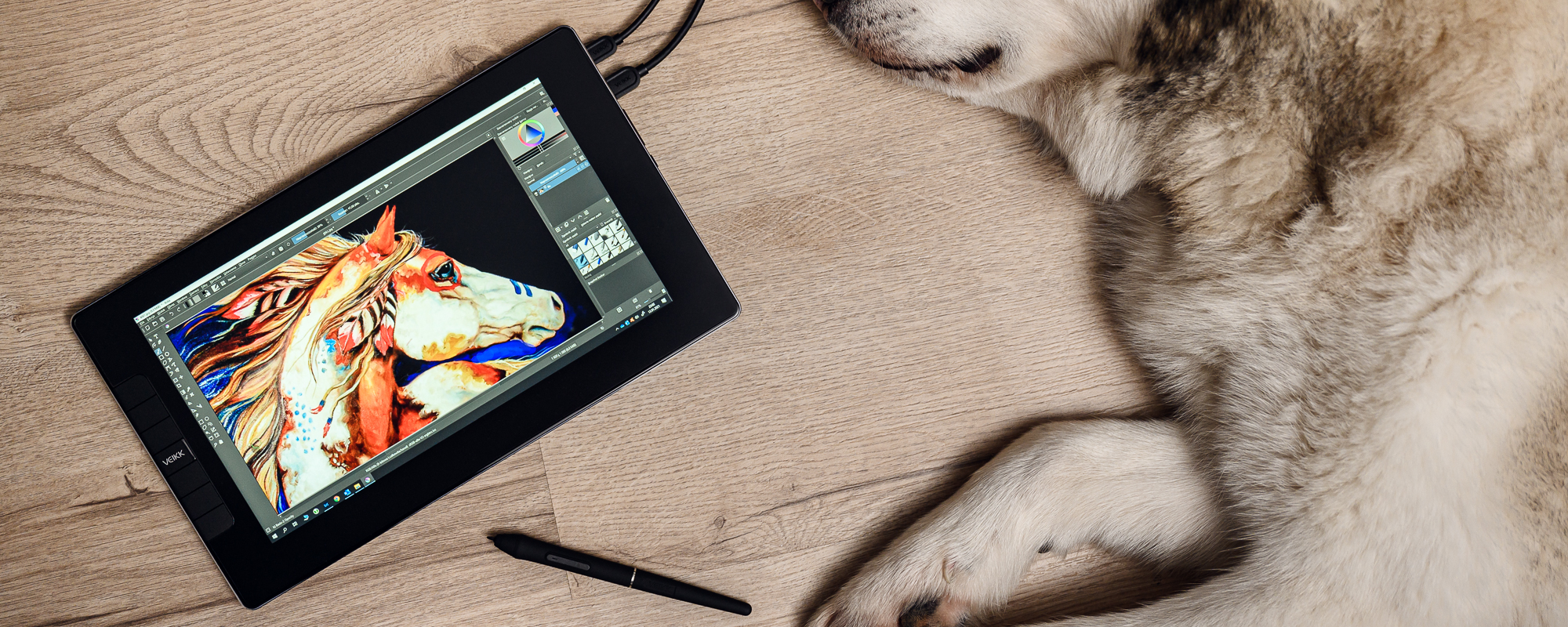 Zdjęcie - tablet graficzny z ekranem LCD Veikk VK1200 leżący na jasnych panelach obok psa